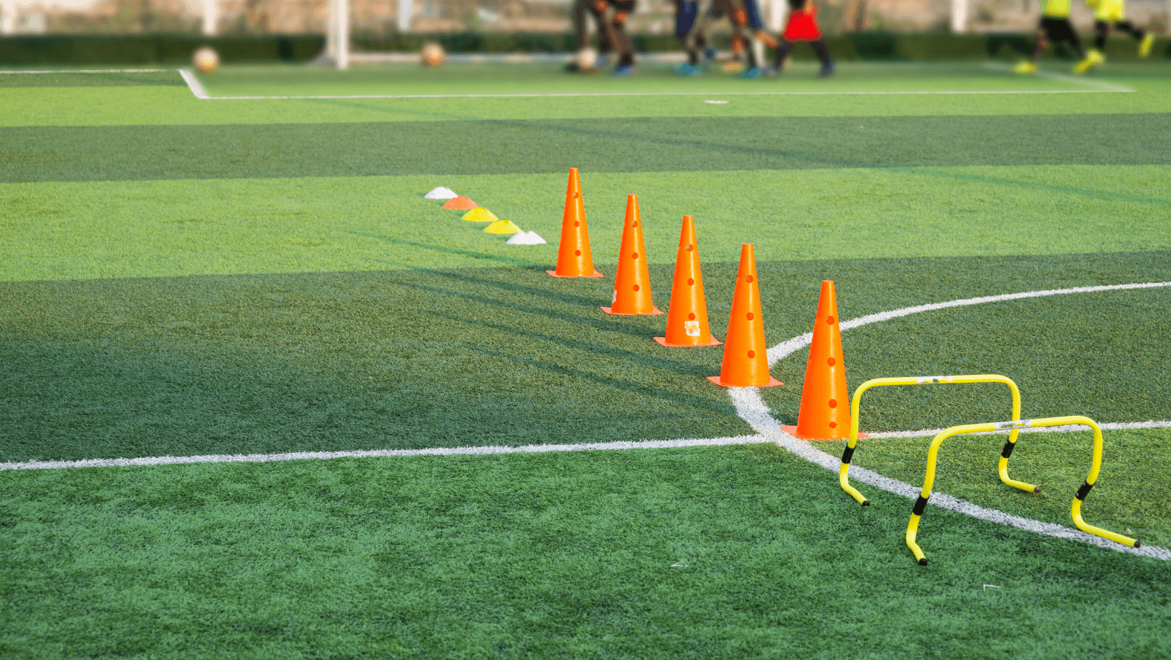Young children playing football together on a sunny field